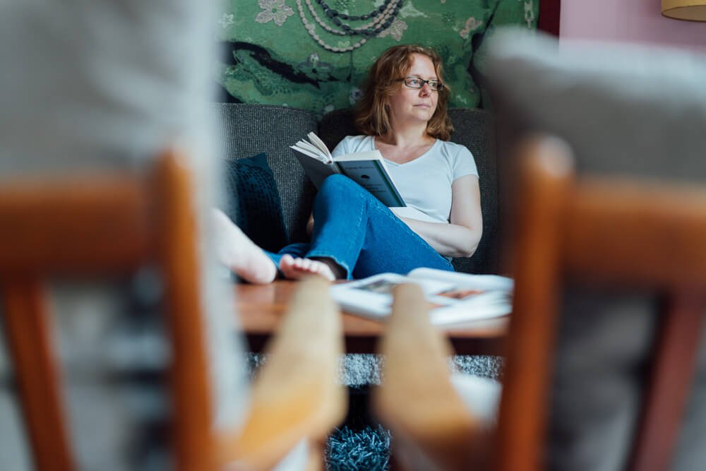 Personal Branding Fotoshooting Martina Komm 00037 Frau sitzt auf dem Sofa mit einem Buch - Bild von einem Personal Branding Shooting
