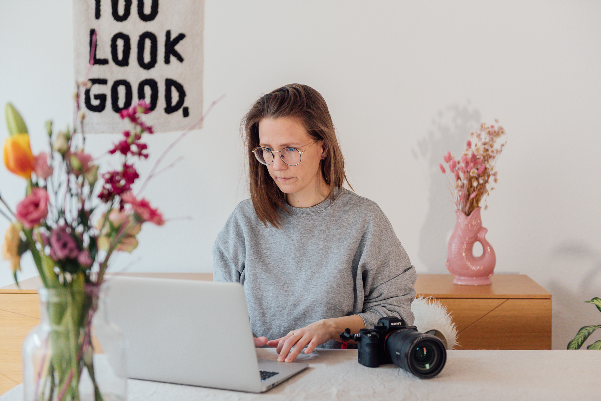 Personal-Branding-Businessfotografin-Mirjam-Kilter-1 Fotografin Mirjam Kilter sitzt mit ihrer Kamera am Tisch an einem Macbook
