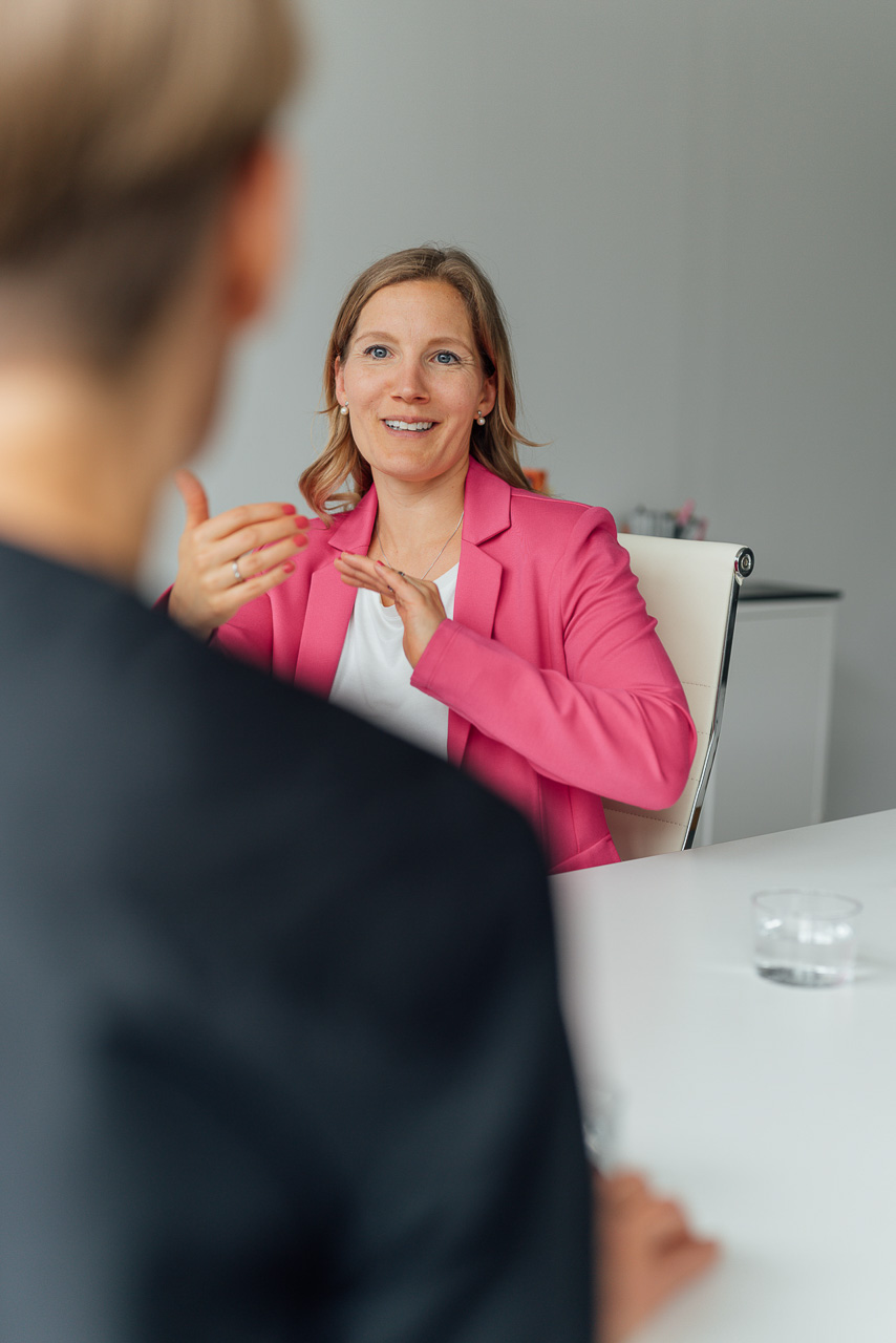 Beispiel-Arbeitssituation-Brand-Shoot-1-mobil Businessfoto die eine Coaching Situation zeigt, zwei Frauen unterhalten sich miteinander und sitzen sich gegenüber.