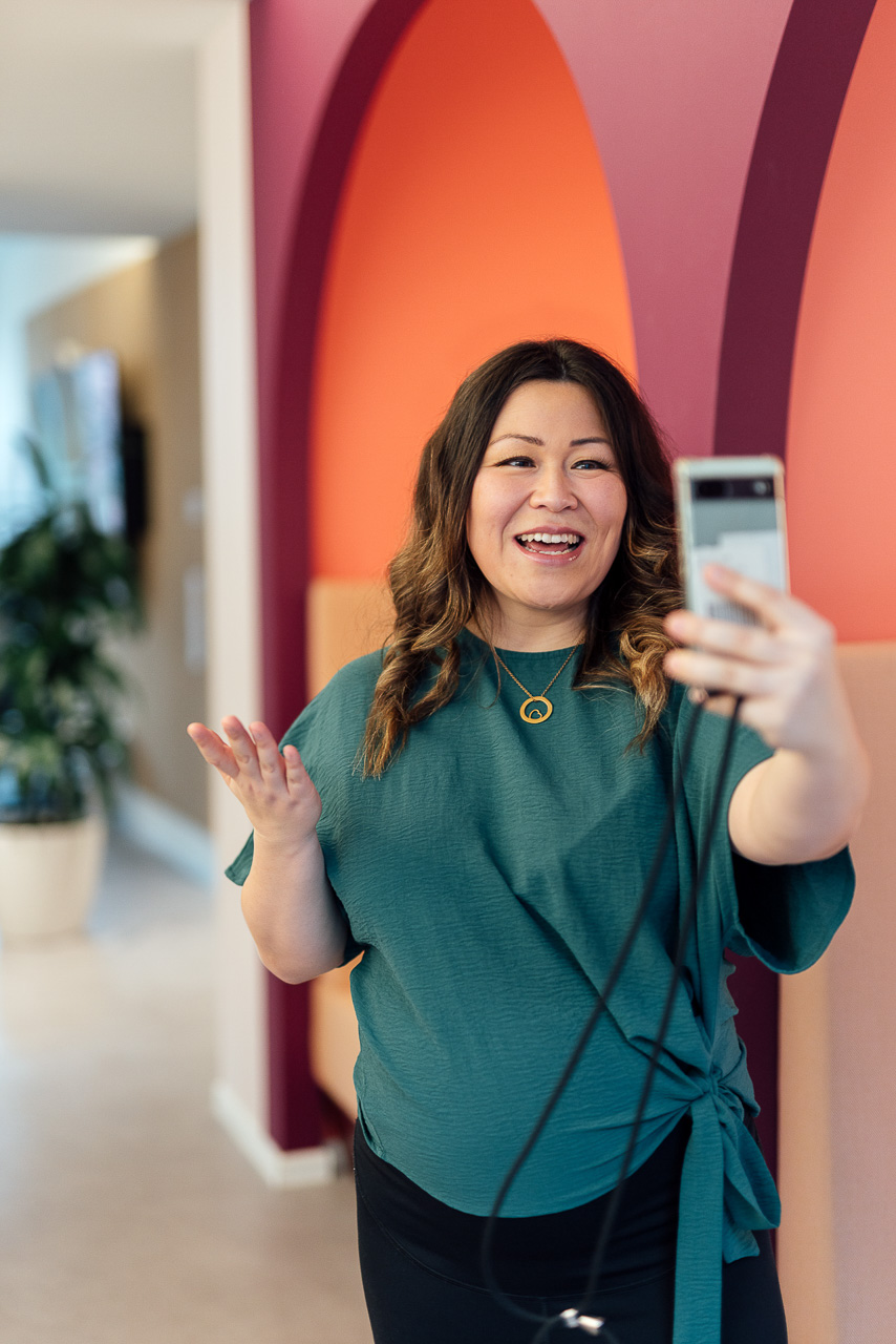 Businessfotos-Corporate-Influencer-Content-Bilder-1-mobil Kreatives Portrait einer Frau, die sich selbst mit dem Handy aufnimmt, das Bild ist während eines Corporate Influencer Days entstanden.