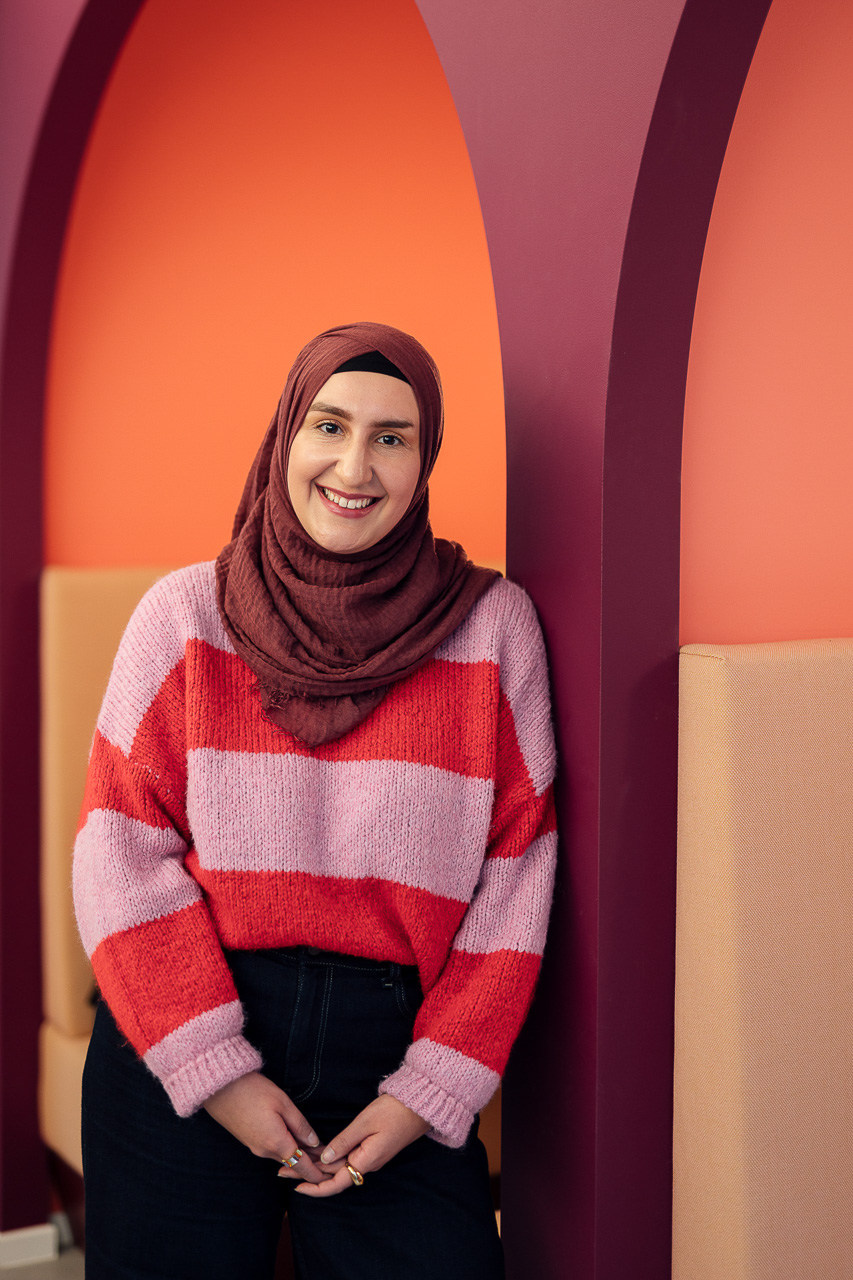 Businessportrait-Corporate-Influencer-Content-Bilder-2-mobil Sympathisches Portrait einer Frau, die an einer Wand lehnt, das Bild ist während eines Corporate Influencer Days entstanden.