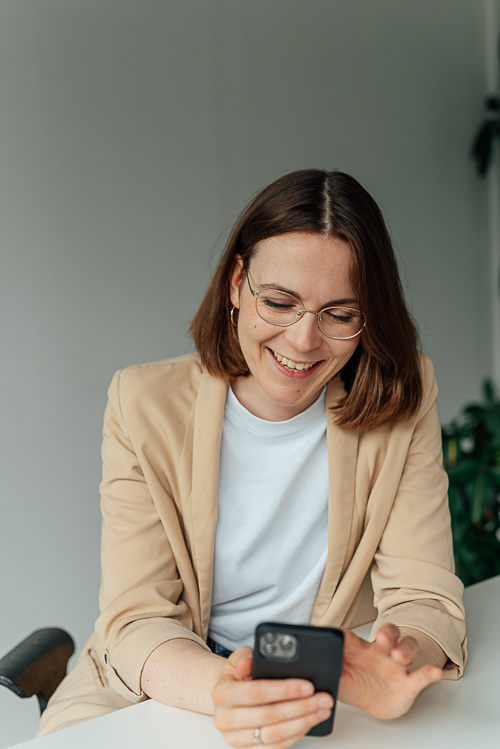 Portrait einer Frau die während eines Brandshoots am Tisch sitzt und den Kopf auf die Hände stützt