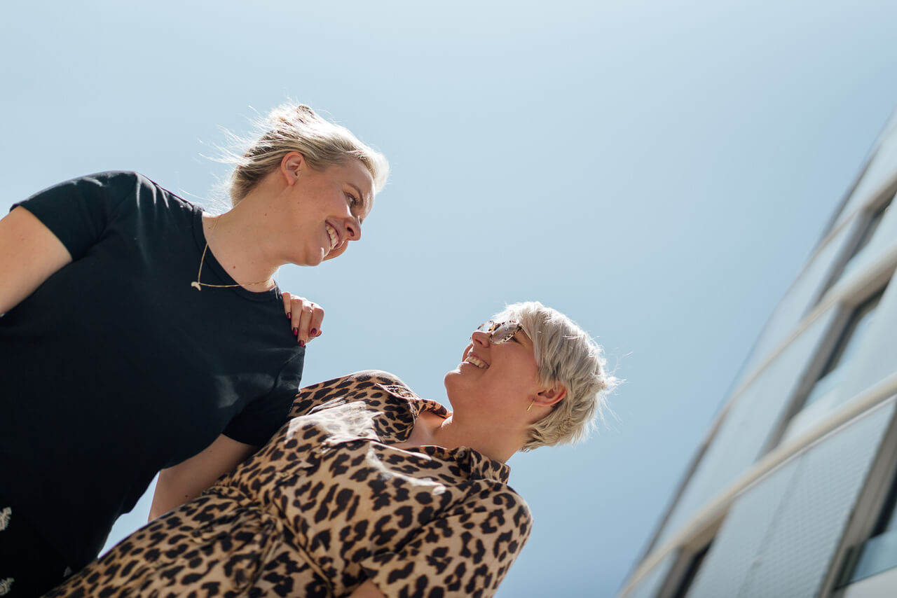 Portrait von Melanie und Sonja von Schockverliebt. Die beiden schauen sich an und man sieht den Himmel. 