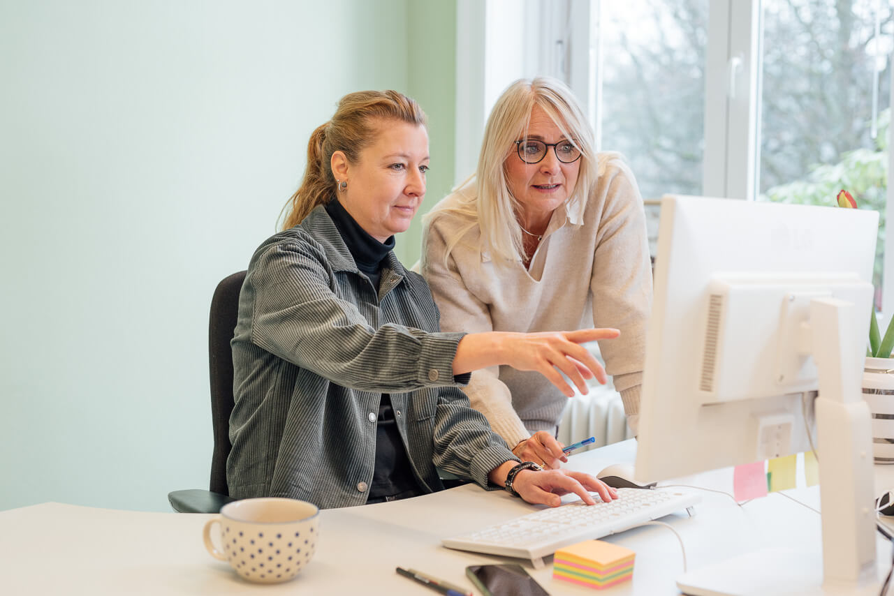 Portrait einer Frau, die eine Tasse in der Hand hält und an der Wand lehnt. Entstanden ist das Bild während eines Brandshoots
