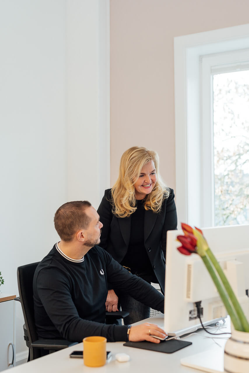 Mitarbeiter vor einem Bildschirm im Gespräch während eines Corporate Fotoshooting
