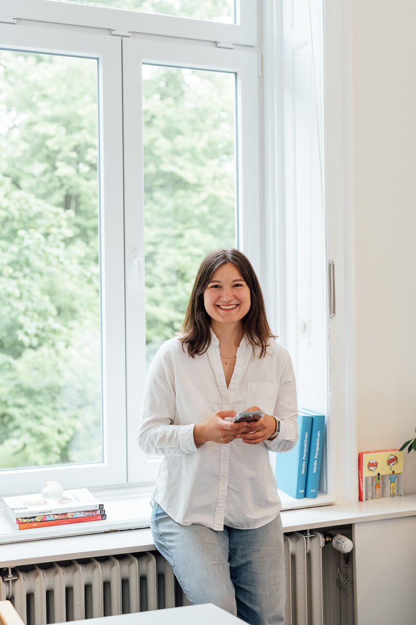 Zwei Frauen stehen am Tisch und sortieren für einen Design Workshop Materialien 