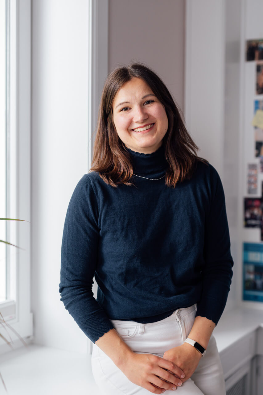 Businessfotograf-Hamburg-Imagefotos-19 Eine Frau sitzt lachend auf dem Boden in Jeans und weißer Bluse. Das Bild ist ein schönes Beispiel für ein Businessfoto, das die Persönlichkeit zeigt.