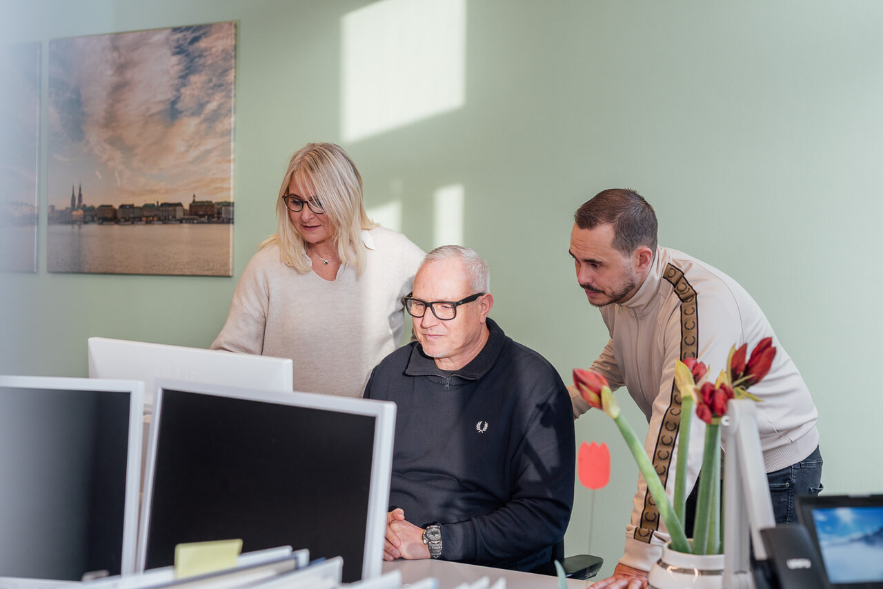 Mitarbeiter vor einem Bildschirm im Gespräch während eines Corporate Fotoshooting