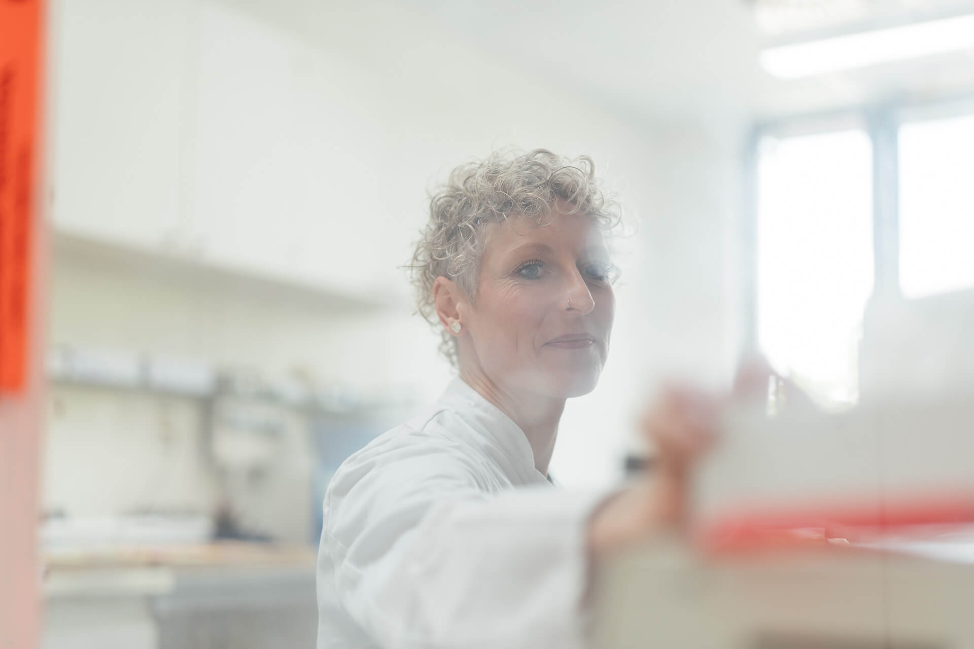 Portrait einer Medizinische Technologin für Laboratoriumsanalytik, fotografiert durch eine Milchglasscheibe