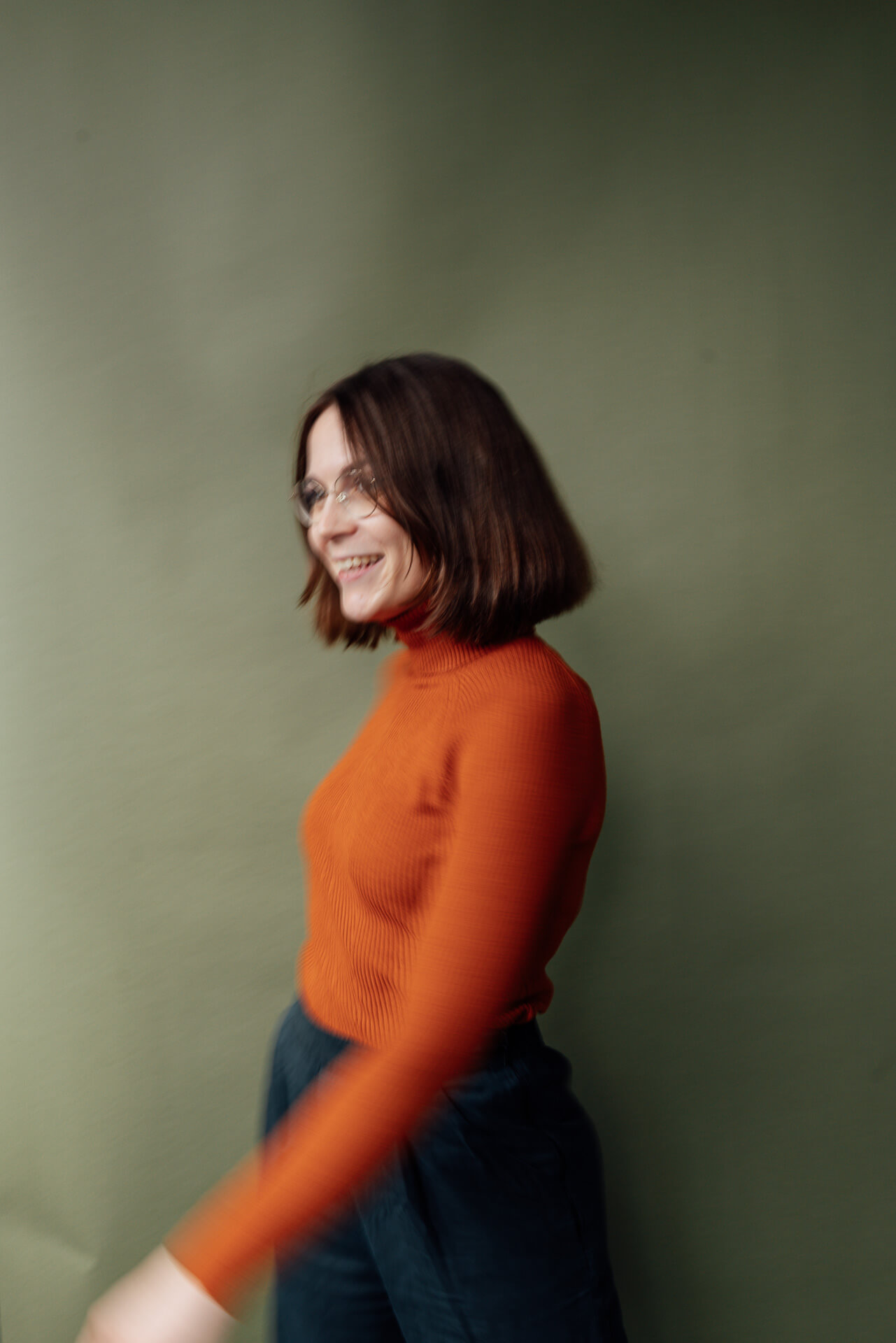 Studio-Days-Hamburg-Beispielbild-vor gruenem-Hintergrund Portrait einer Frau im orangenen Longshirt, die vor einem grünen Hintergrund steht