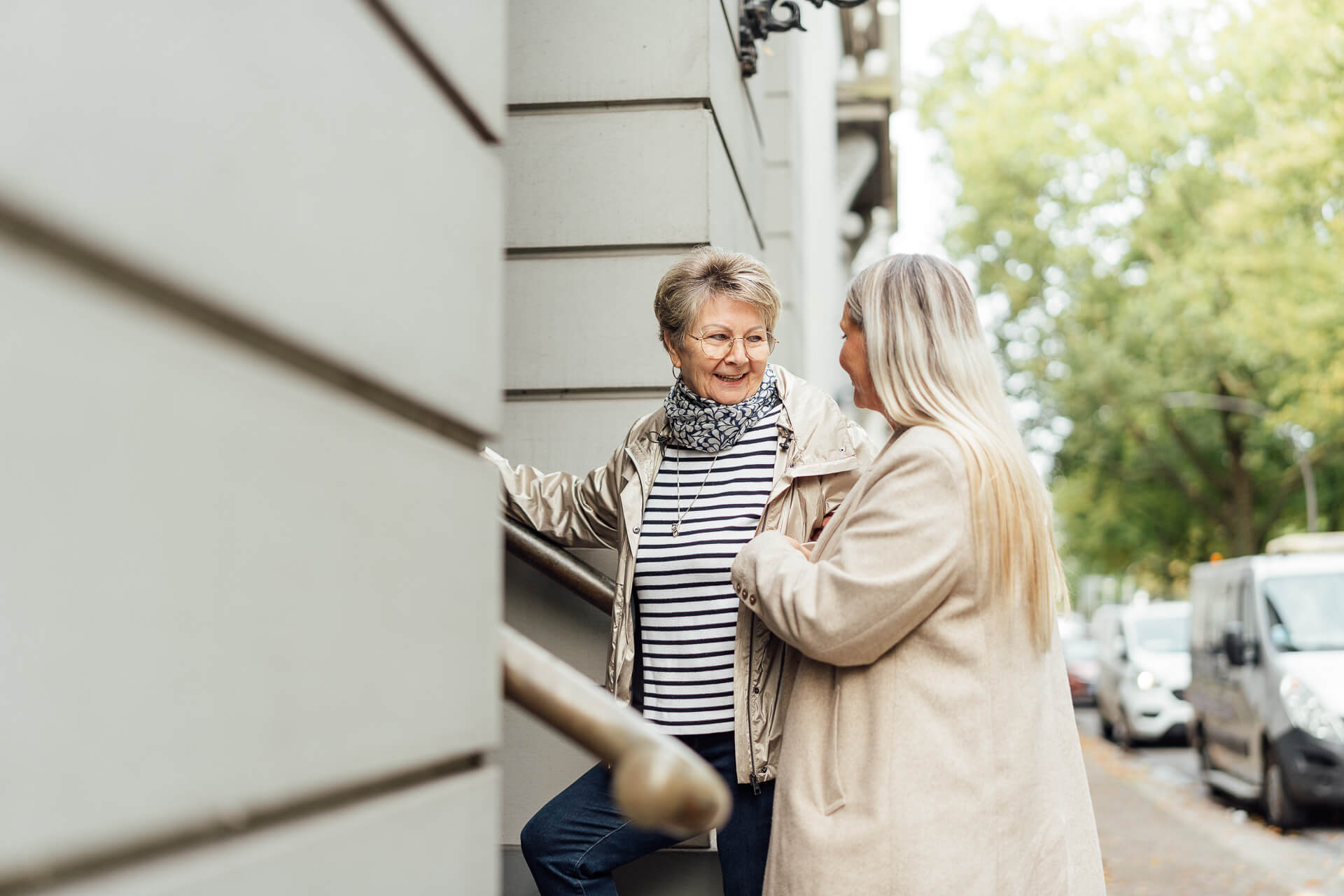 Fotoshooting-haeusliche-Betreuung-Hamburg-15 Das Bild zeigt eine Seniorin und ihre Pflegeperson, sie hilft ihr gerade ins Haus