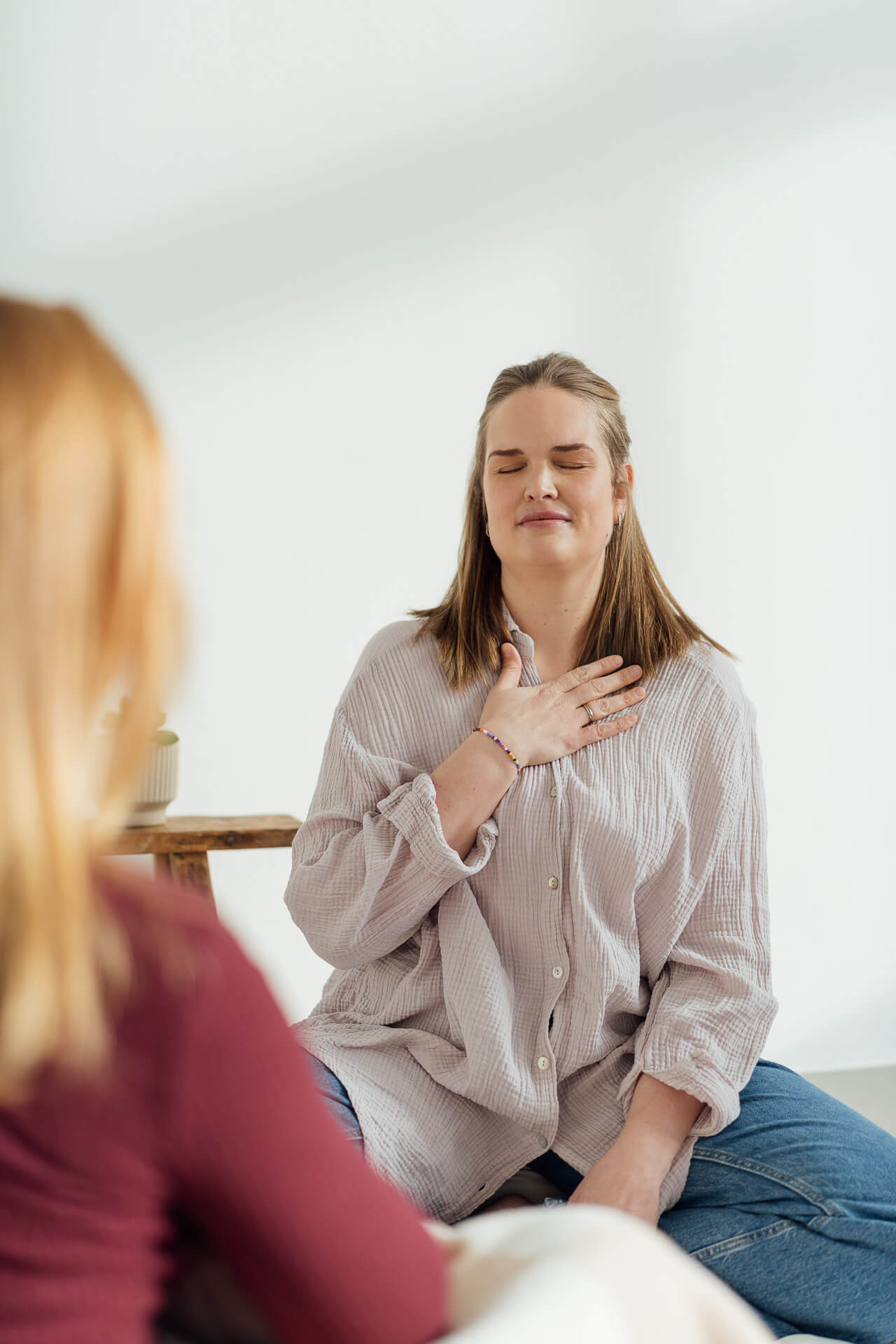 Portrait einer Frau im roten Blazer, die vor einem grünen Hintergrund steht
