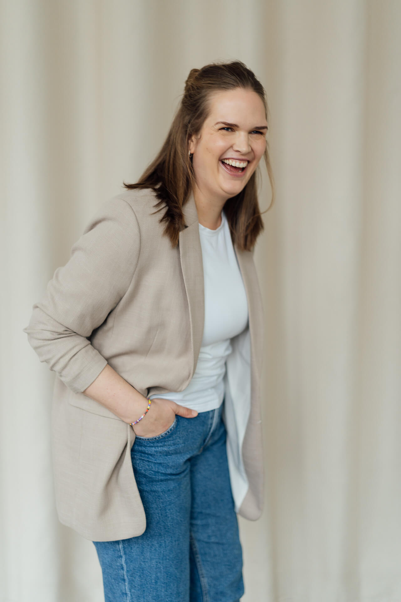 Portrait einer Frau, die auf einem orangenen Sofa sitzt.