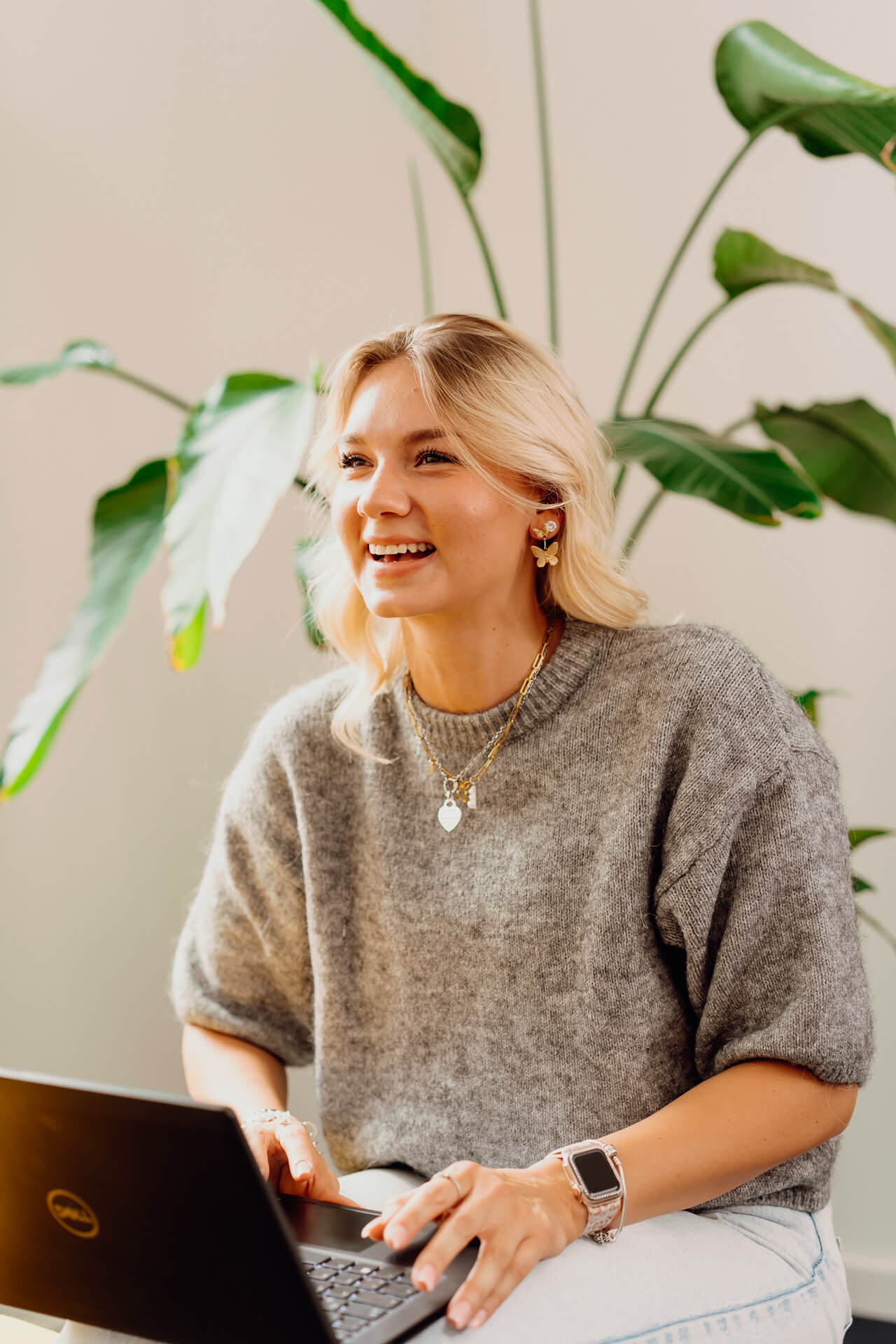 Portrait-Mitarbeiterin-Corporate-Business-Shooting-2 Unternehmensportrait einer Mitarbeiterin die einen Laptop auf dem Schoss hat und zu einer Kollegin schaut, die aber nicht im Bild zu sehen ist