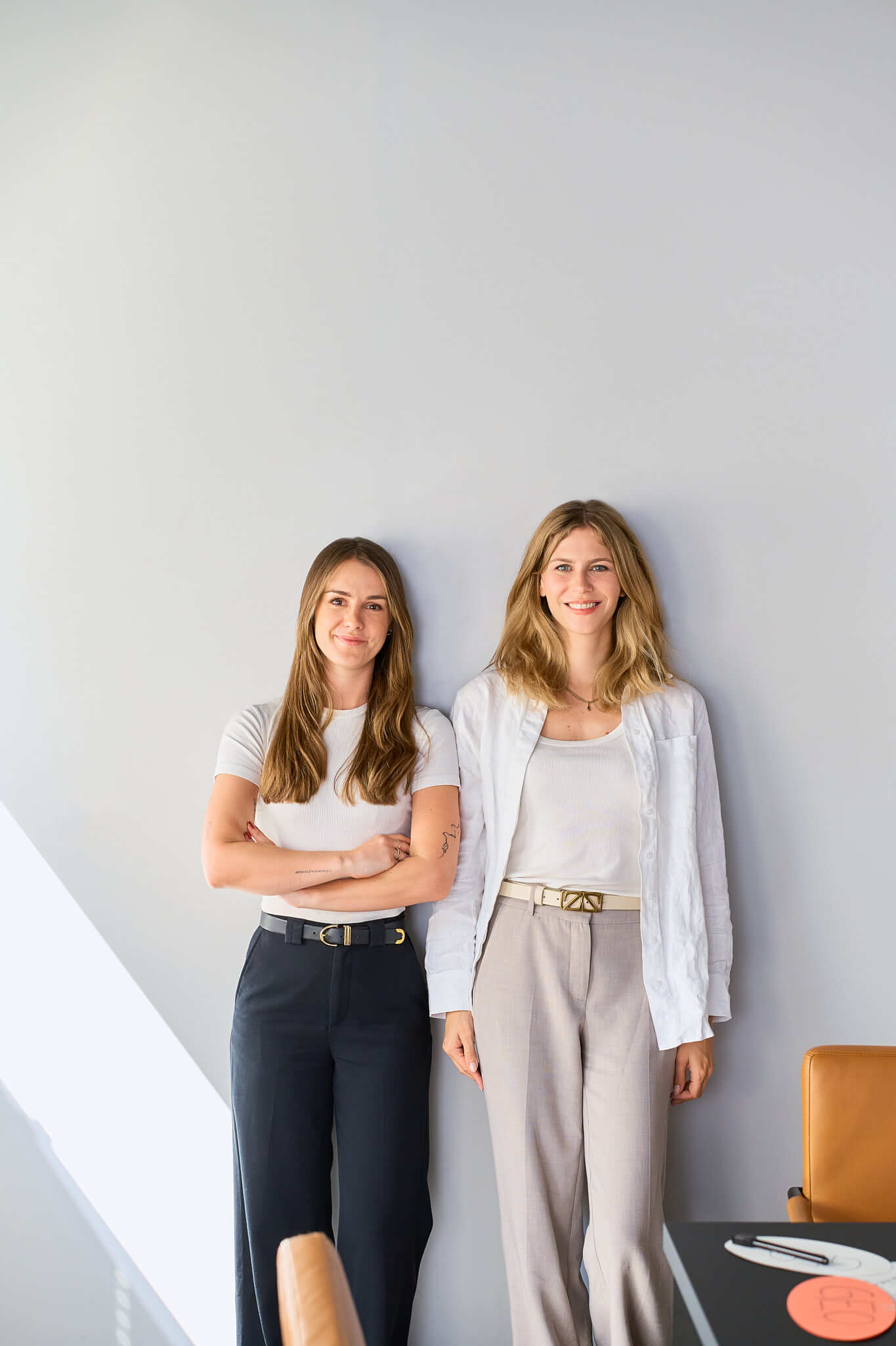 businessfotos-seo-agentur-portrait-geschaeftsfuehrerinnen Businessportrait der beiden Geschäftsführerinnen einer SEO-Agentur, an eine Wand gelehnt